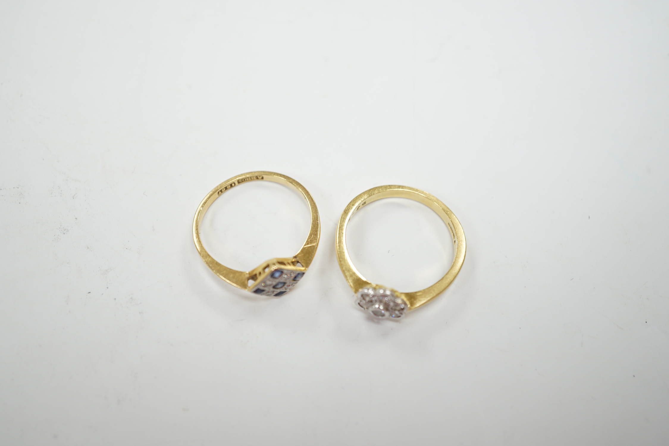 A 1920's 18ct, sapphire and diamond millegrain set cluster ring, size O/P, and a later 18ct gold and seven stone diamond set flower head cluster ring, gross weight 6.3 grams.